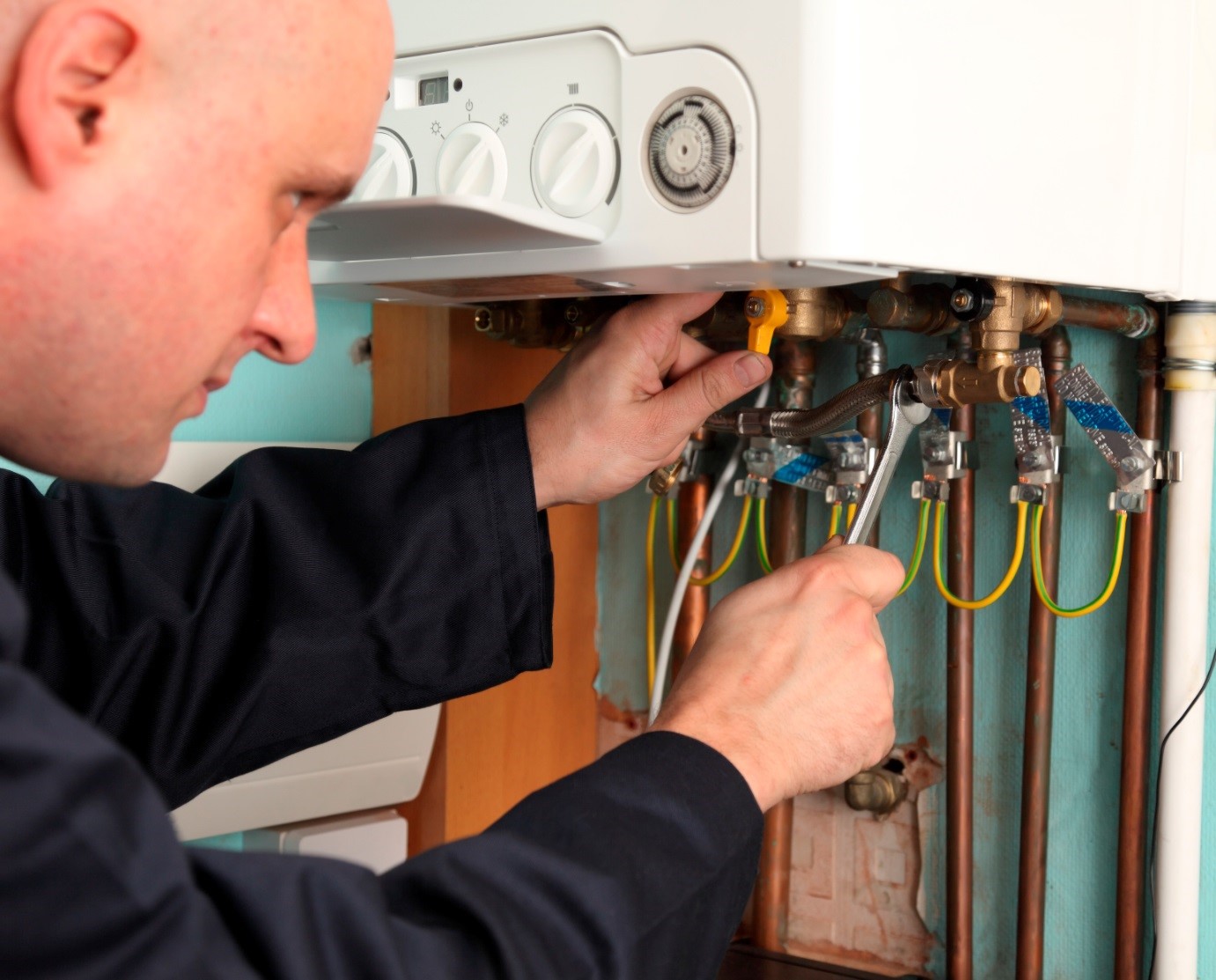 Heating engineer diagnosing a fault on an older gas boiler